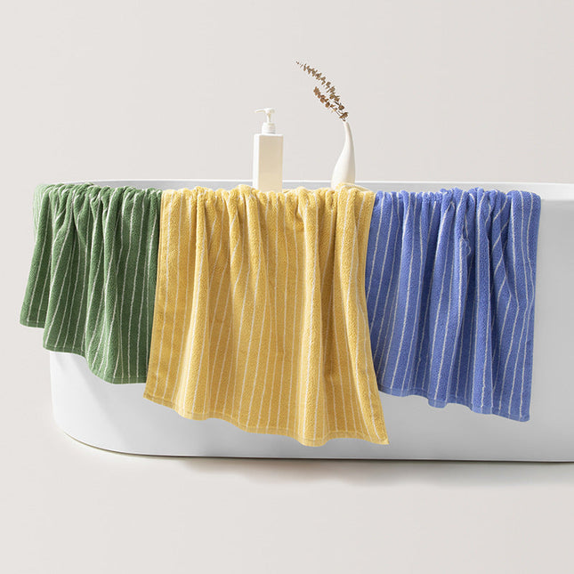 Three colorful towels hanging over a bathtub with a white background