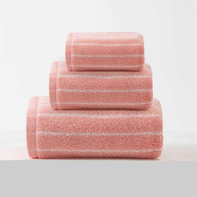Stack of three pink towels on a light gray background