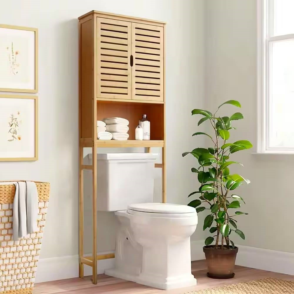 Bathroom with wooden over-the-toilet storage cabinet, white toilet, and potted plant.