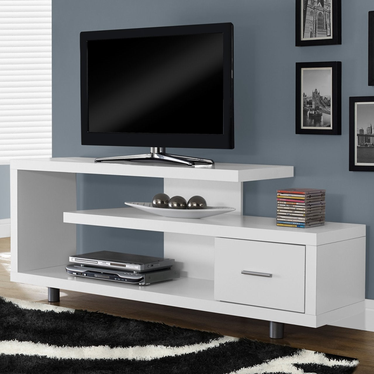 White TV stand with a black television mounted on a gray wall.
