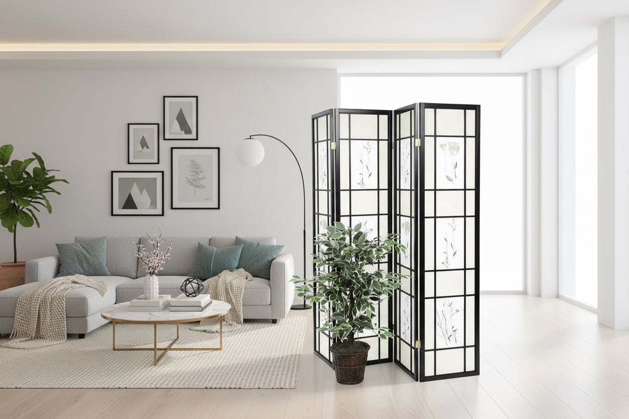 Black folding screen with white floral patterns next to a potted plant on a white background