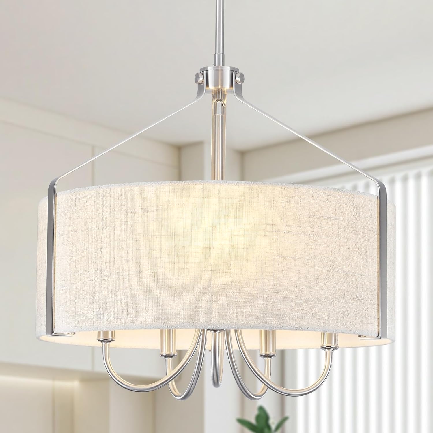 Modern pendant light with a beige fabric shade in a room setting