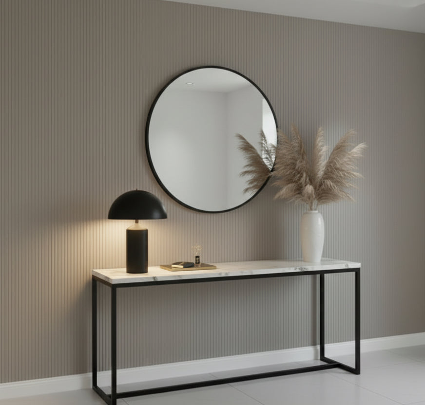 Living room with a fireplace, white sofa, and decorative mirror.