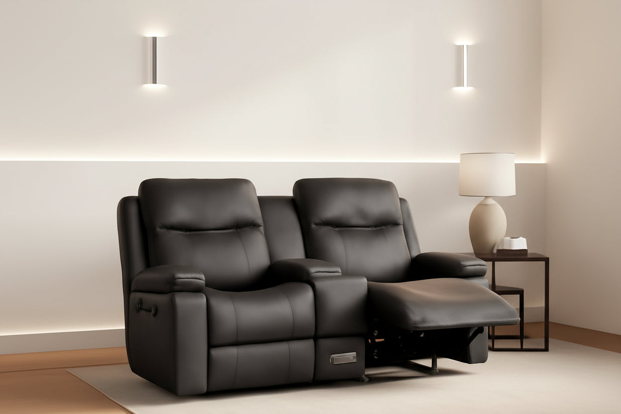 Two black leather recliner chairs in a room with warm lighting.