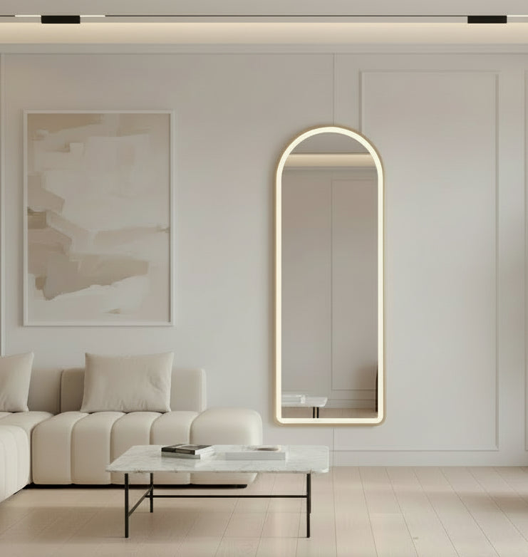 Two illuminated standing mirrors in a room with a fireplace and sofa.