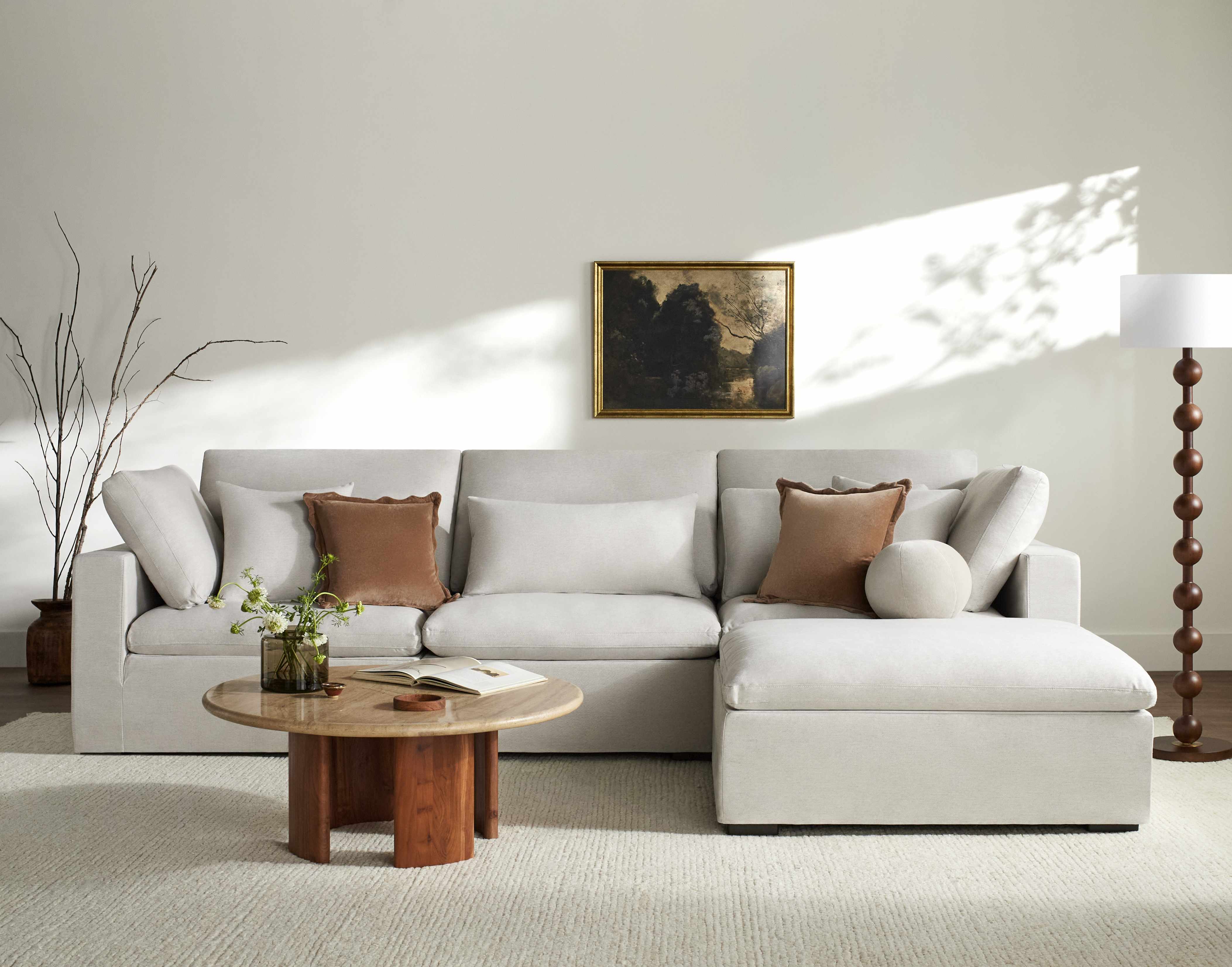 Modern living room with a gray sectional sofa, wooden coffee table, and decorative elements.