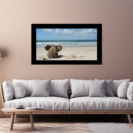 Framed artwork of an elephant on a beach hanging above a white sofa in a living room.