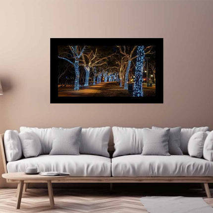 White sofa in a living room with a wall-mounted artwork of a tree-lined path at night.