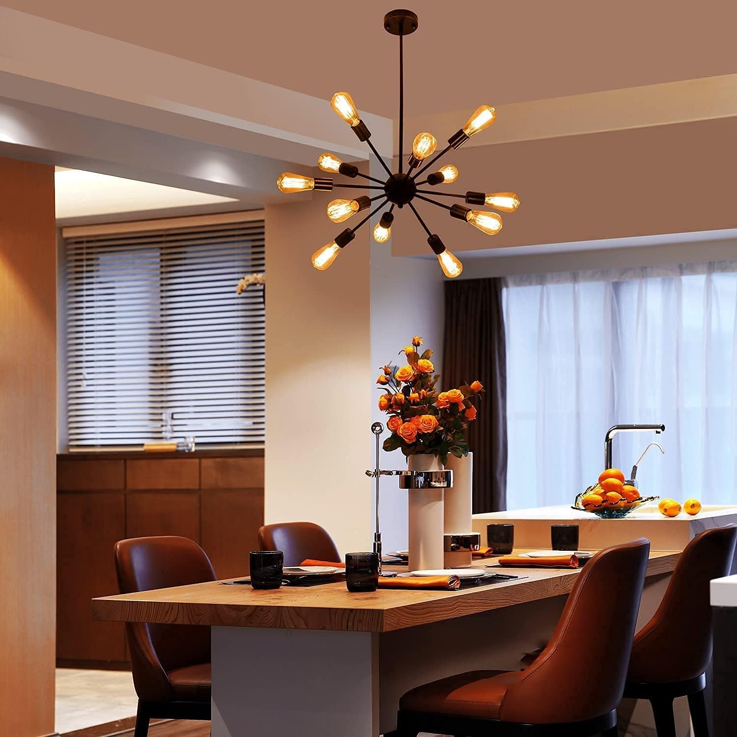 Modern kitchen with a chandelier, dining table, and chairs.