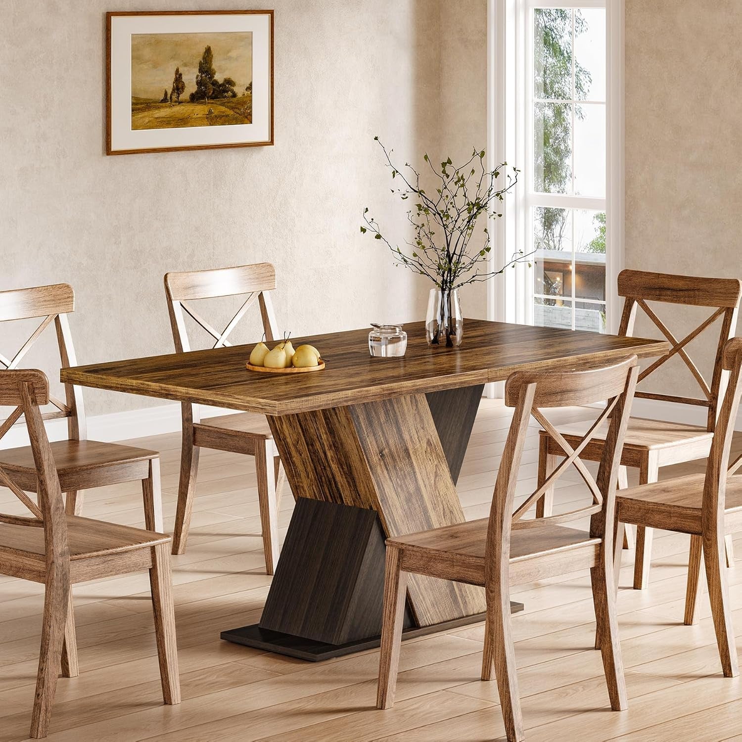 Dining room with wooden table and chairs, featuring a vase with flowers and fruit on the table.