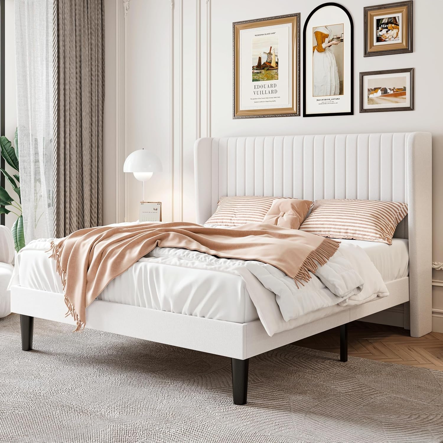 White upholstered bed with beige bedding in a bedroom setting
