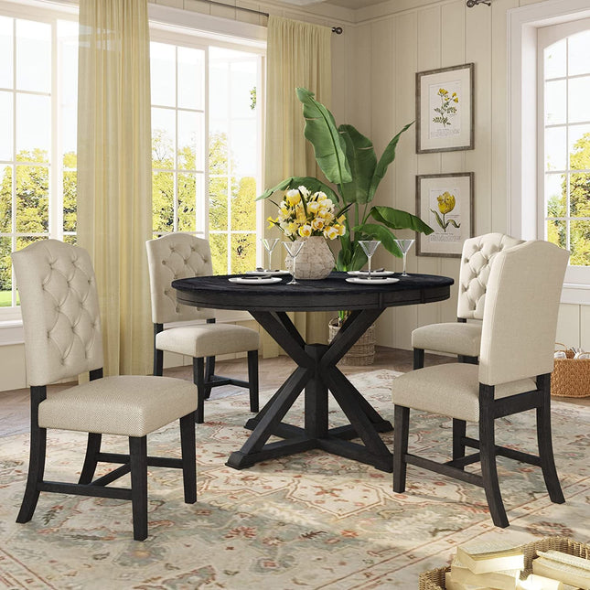 Dining room with a black round table and beige chairs, decorated with flowers and decor items.