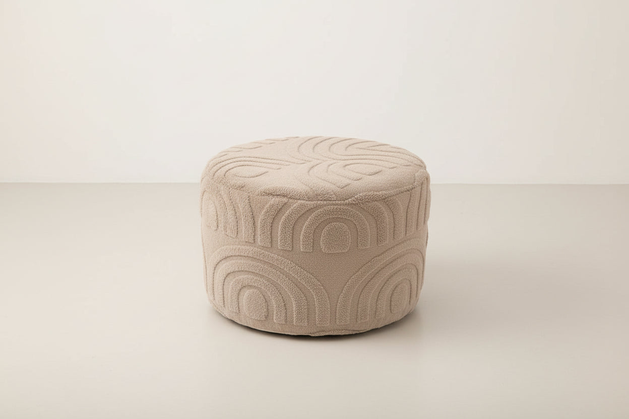 Person sitting on a textured ottoman with feet up on a wooden floor