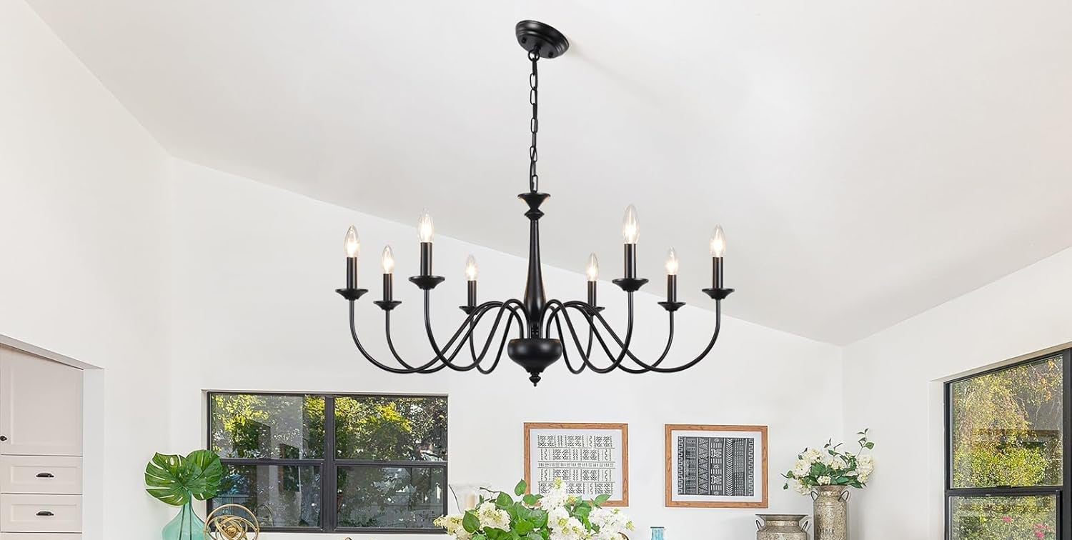 Dining room with a large chandelier, table, and chairs on a wooden floor.