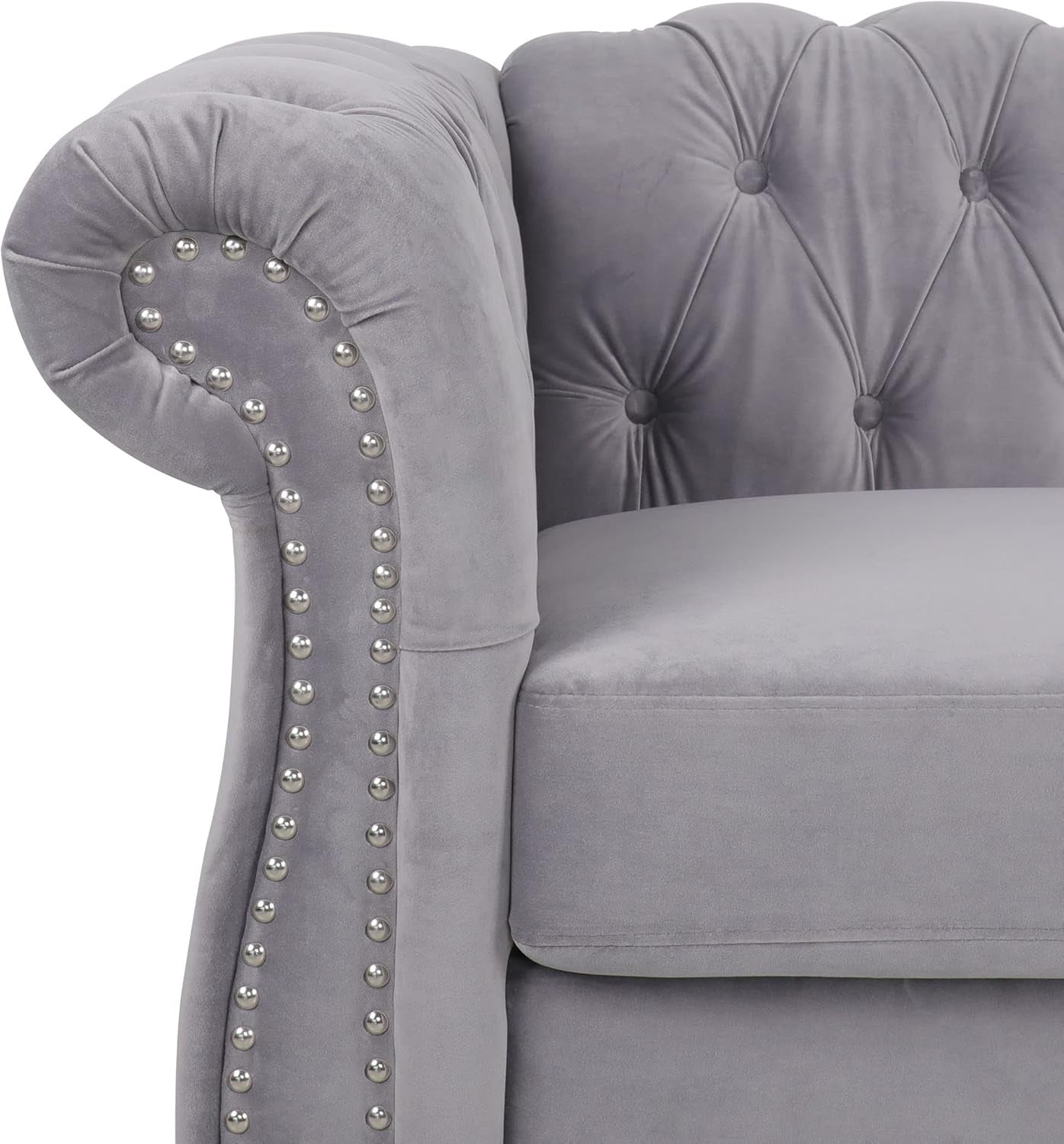 Gray velvet sofa with studded armrests on a white background