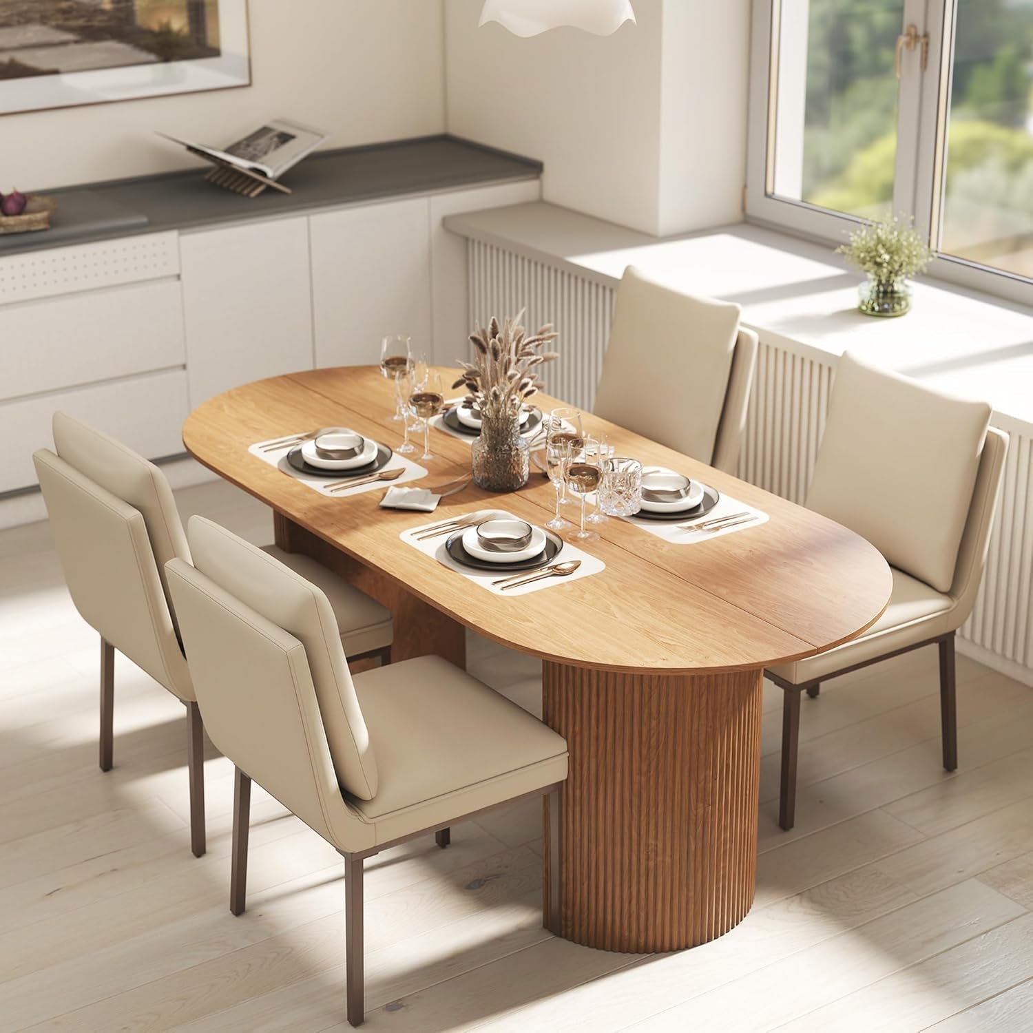 Dining table set with plates, glasses, and cutlery in a modern kitchen.
