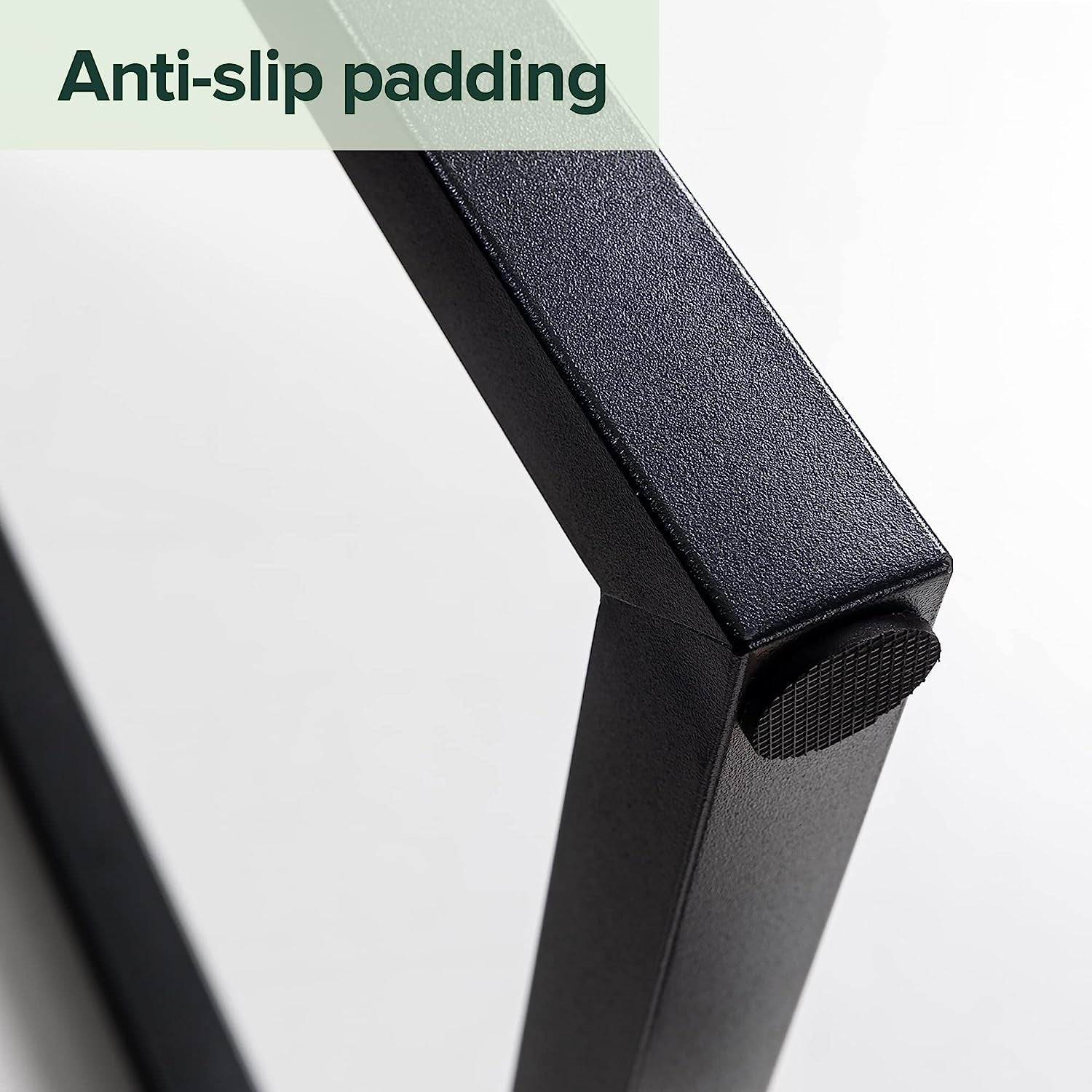 Close-up of a black stand with anti-slip padding on a light gray background