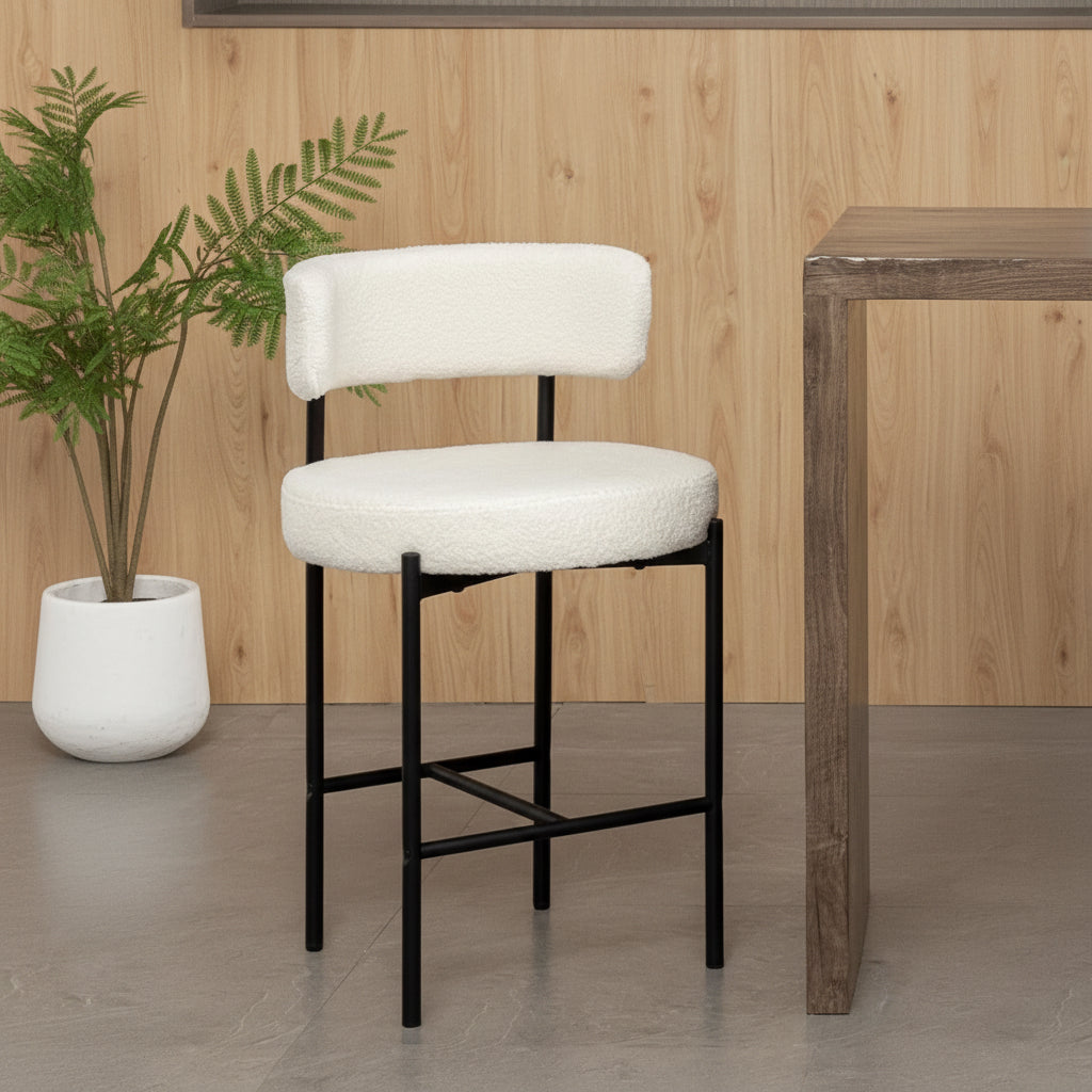 White bar stool with black legs on a wooden floor, featuring ergonomic design elements.