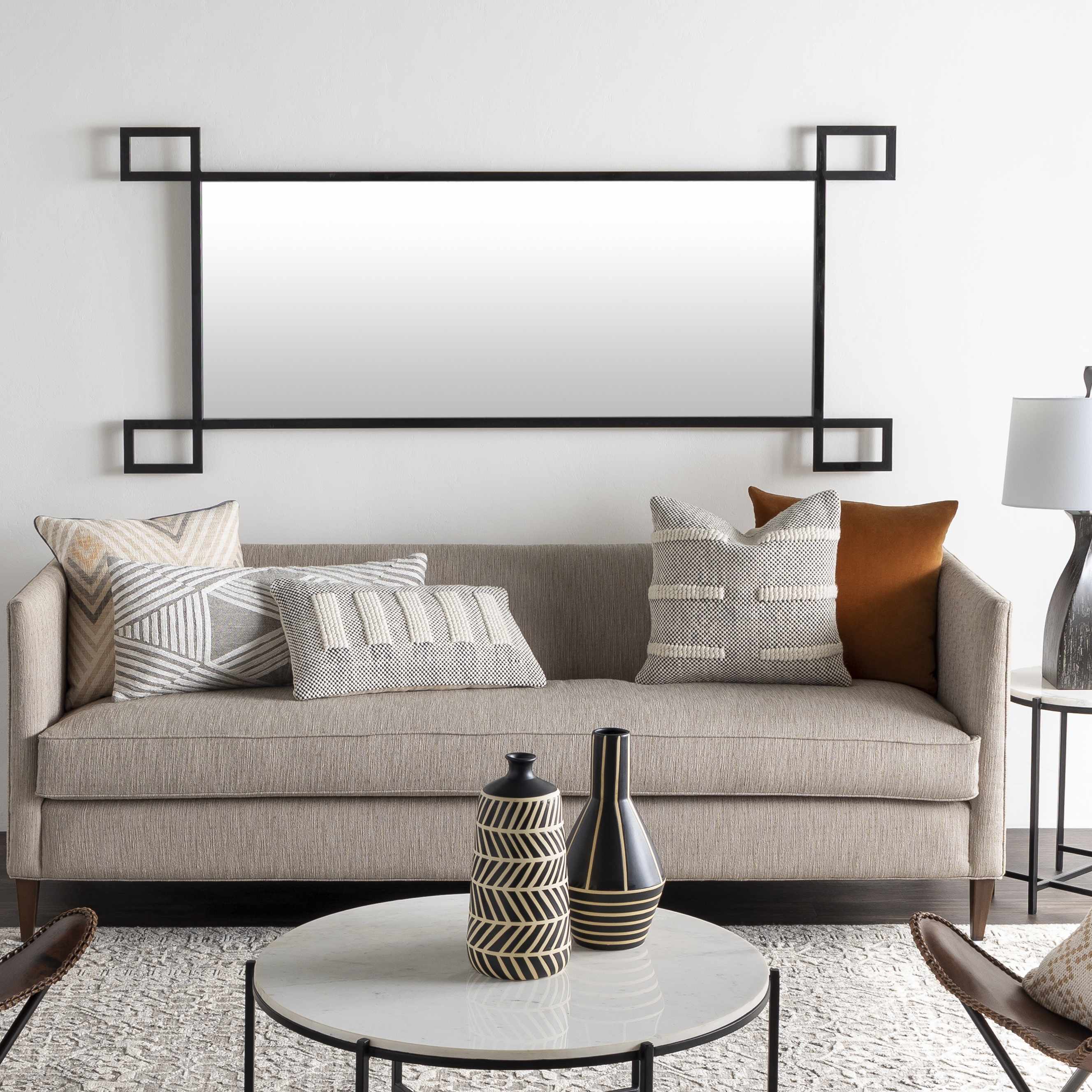 Modern living room with a beige sofa, decorative pillows, and vases.
