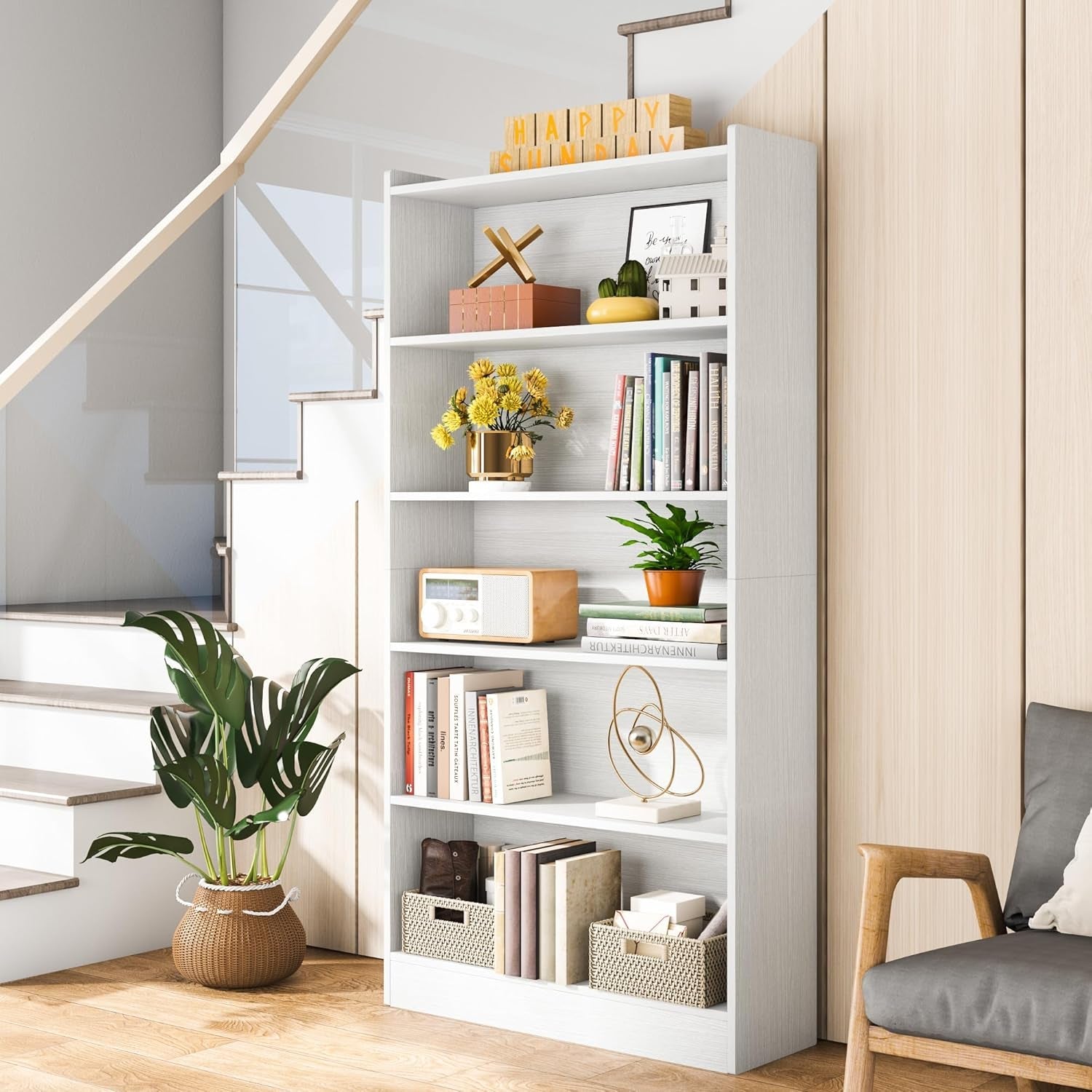 White bookshelf with decorative items in a room with a staircase and chair.