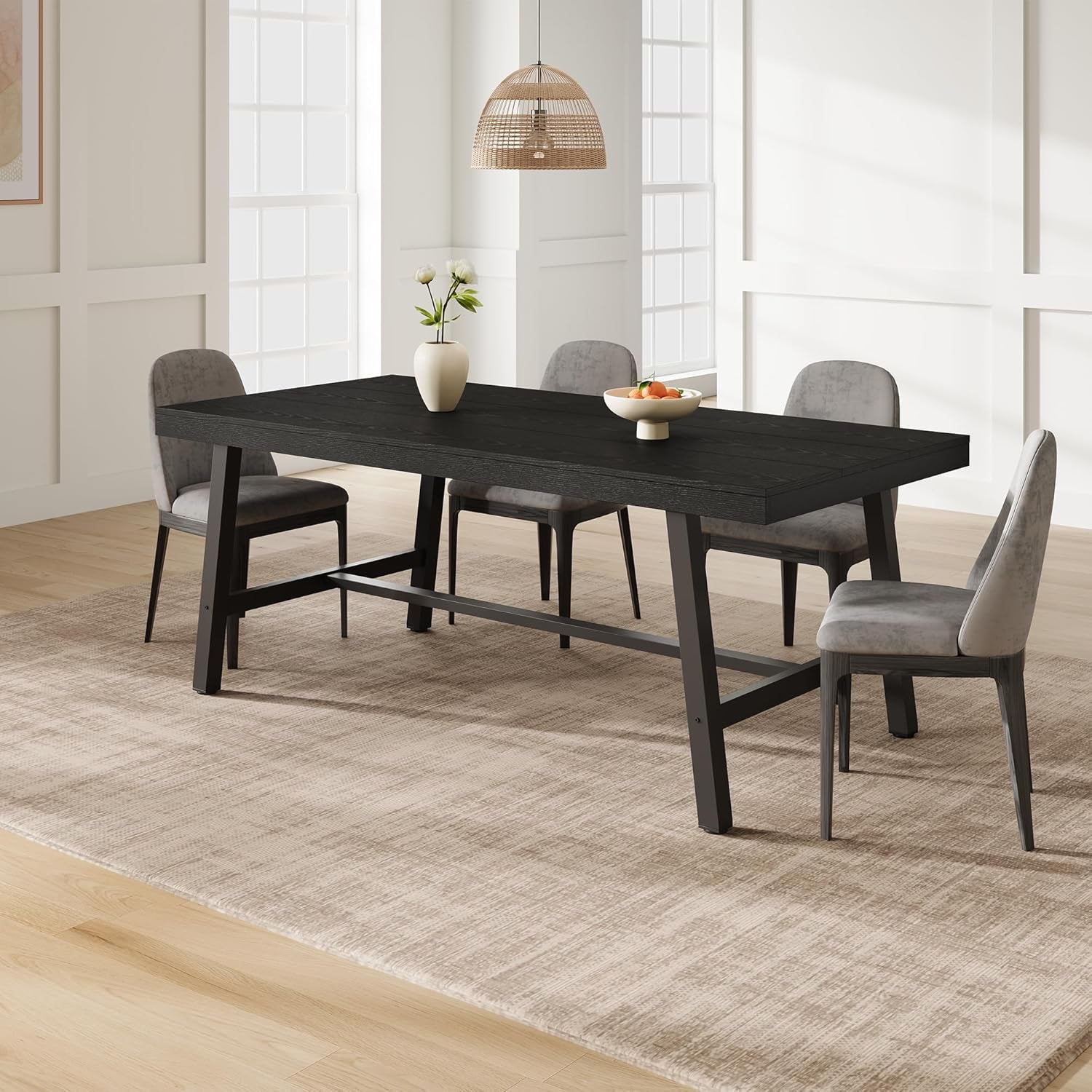 Dining room with a black table and gray chairs on a wooden floor.