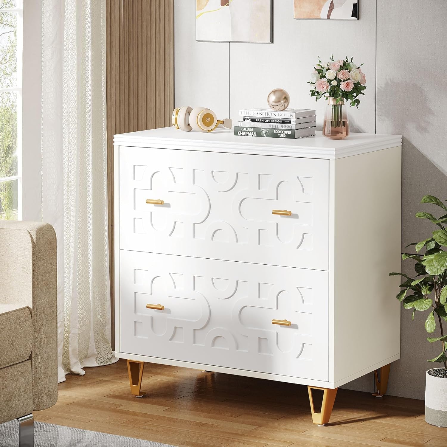 White dresser with gold accents in a room with a couch and plant