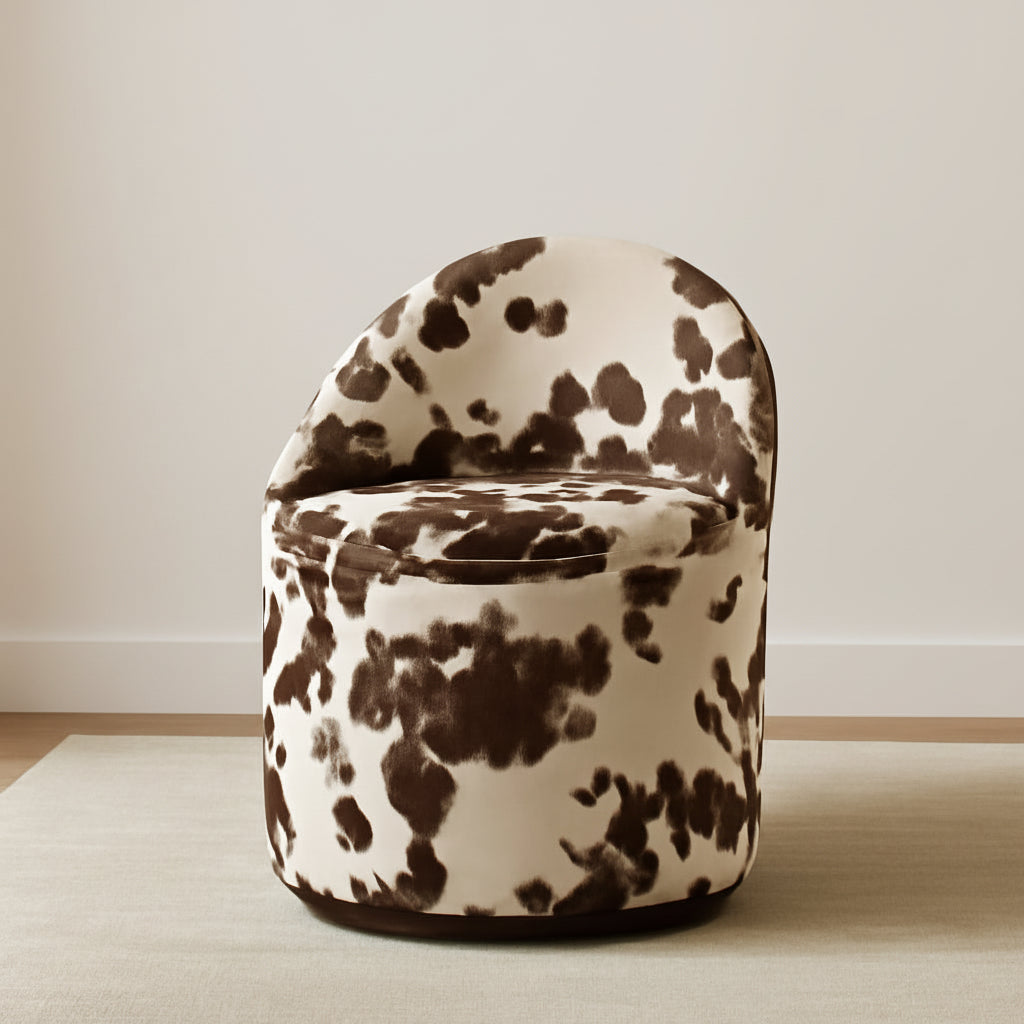 Chair with cow print design in a room with a light-colored wall and wooden floor.