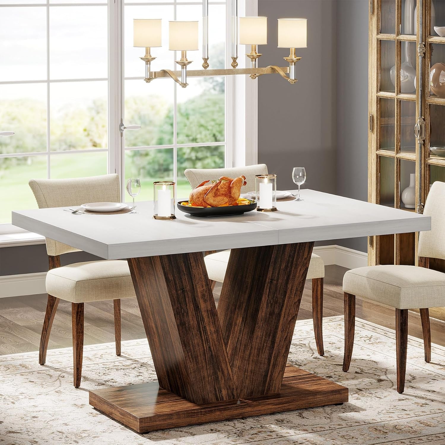 Dining room with a modern table featuring a wooden base and white top, set for a meal.