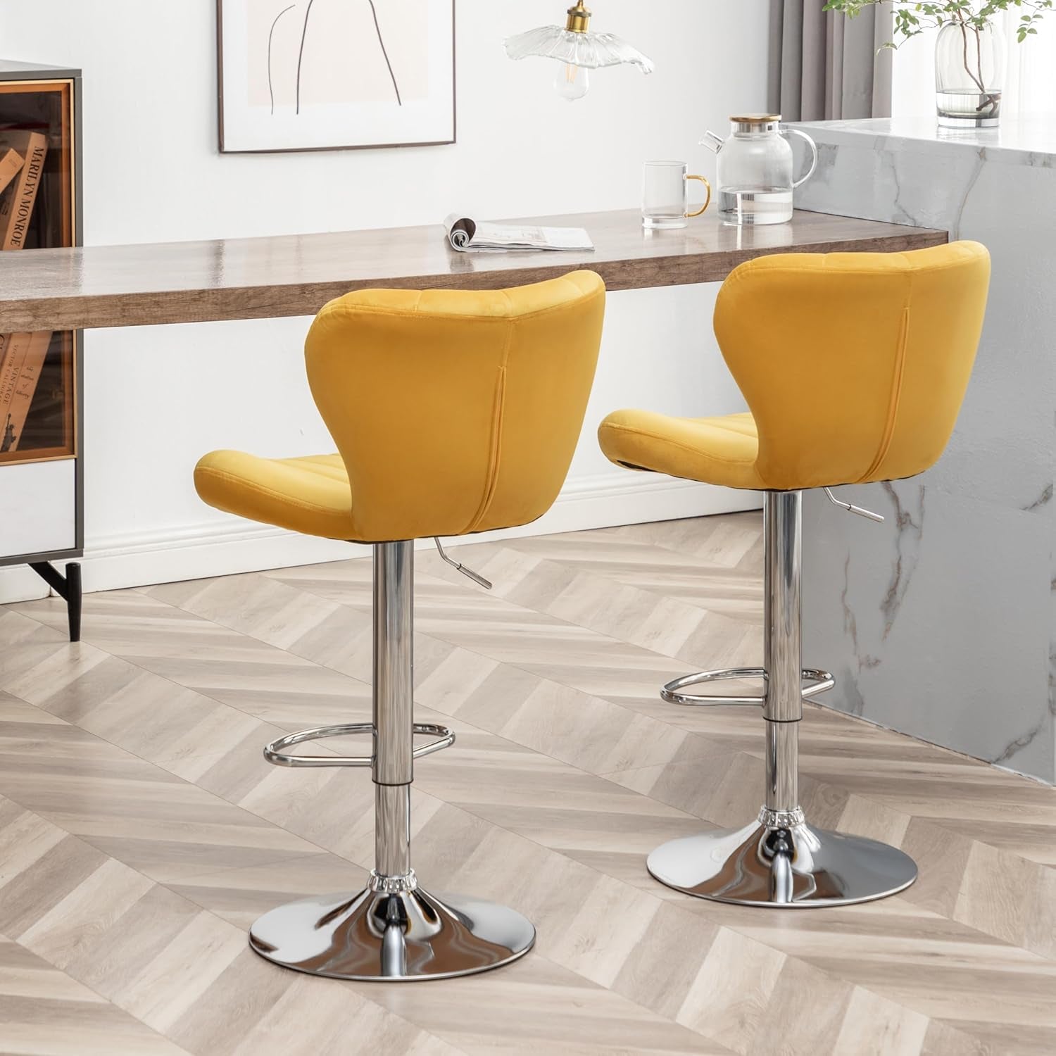 Two yellow bar stools with chrome bases in a kitchen setting.