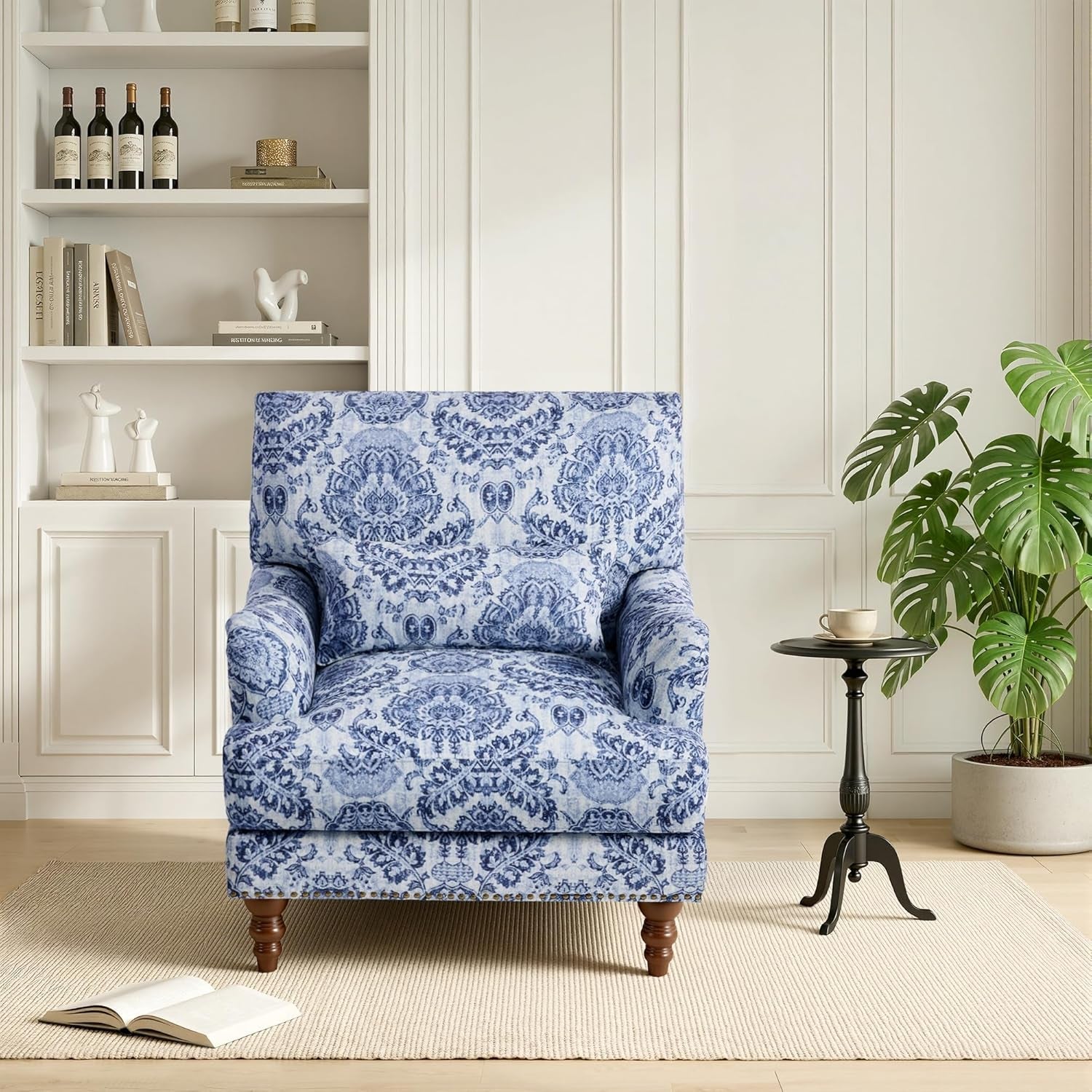 Blue patterned armchair in a living room setting with a bookshelf and plant.