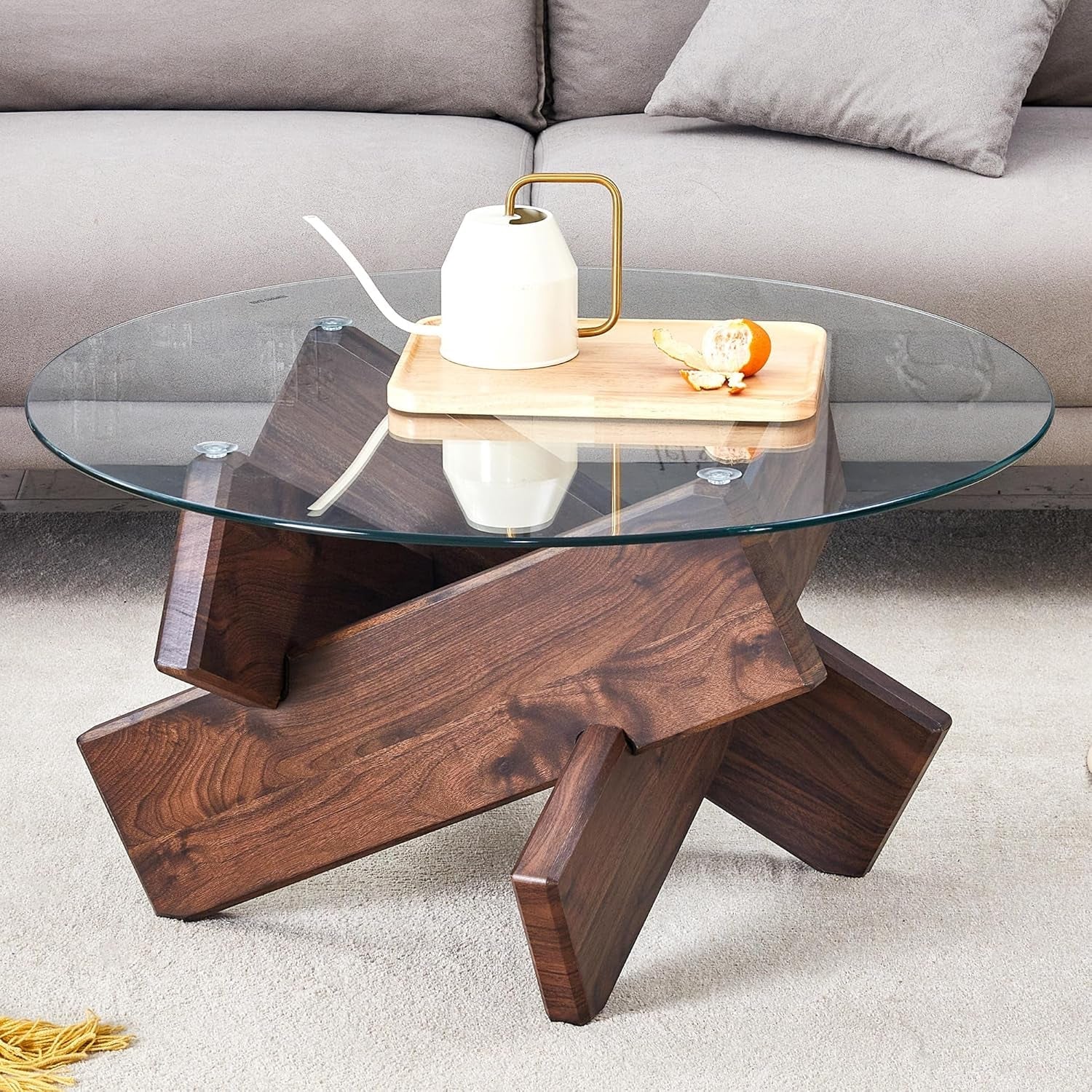 Glass coffee table with wooden base in a living room setting