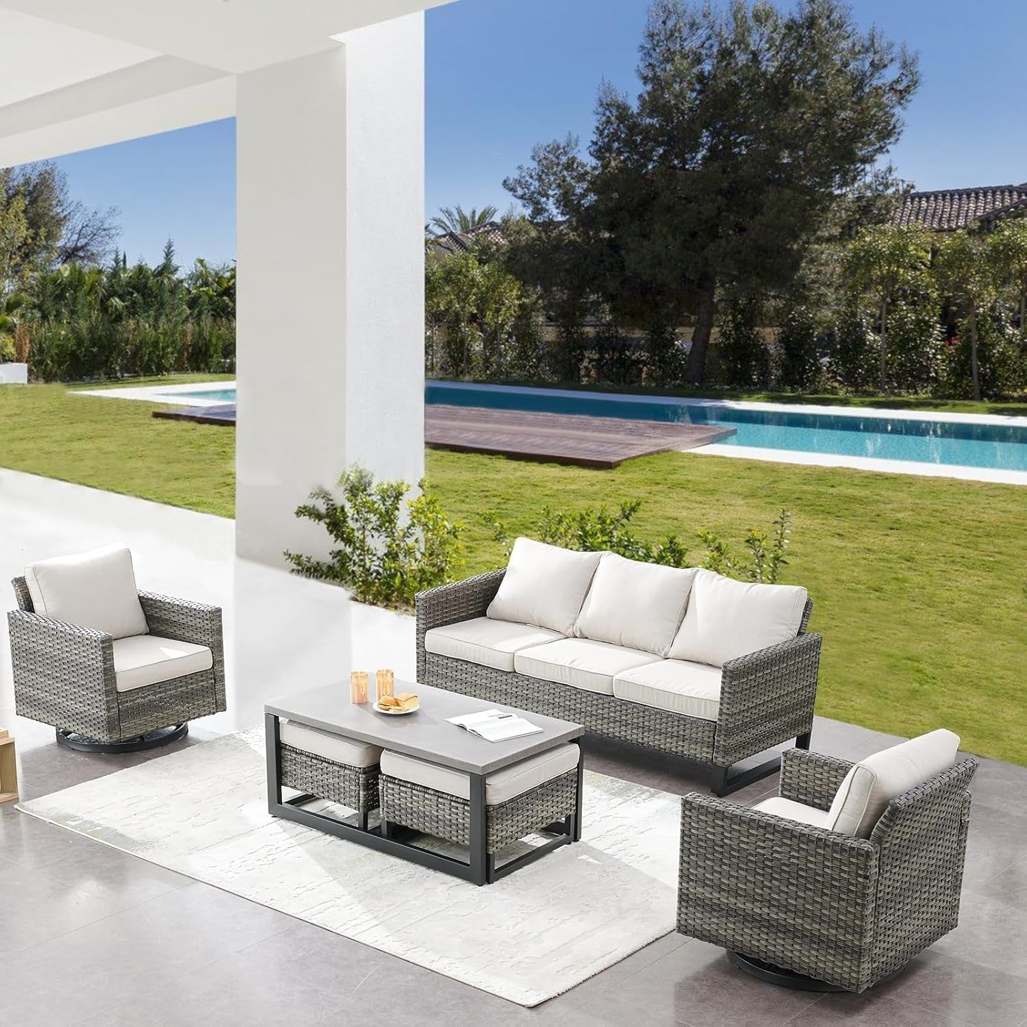 Outdoor patio furniture set with cushions near a pool and garden.