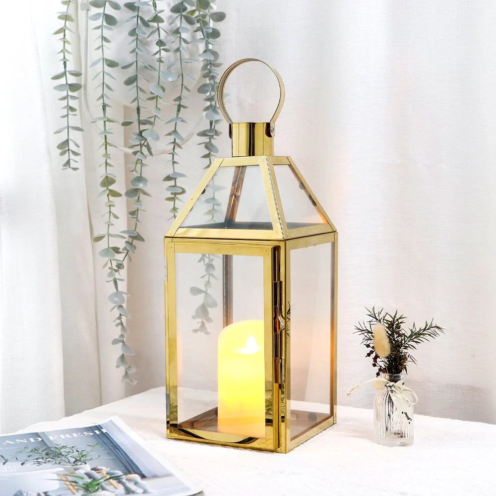 Gold lantern with a candle on a table next to a plant