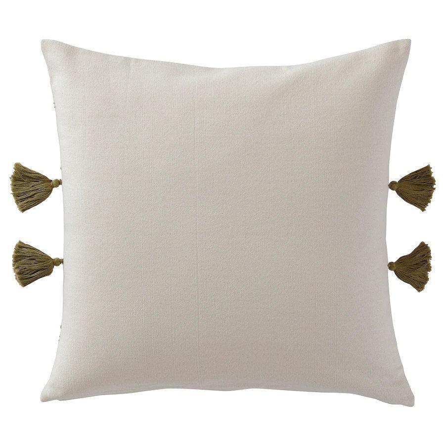 Beige pillow with green tassels on a white background