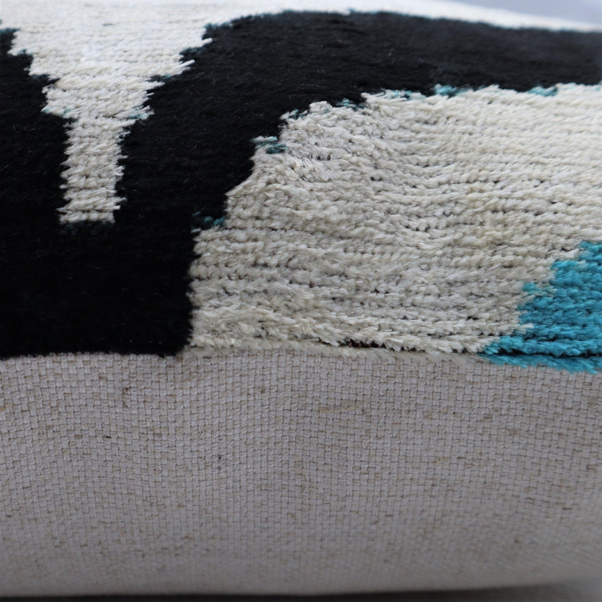 Close-up of a textured fabric with black, white, and blue patterns.