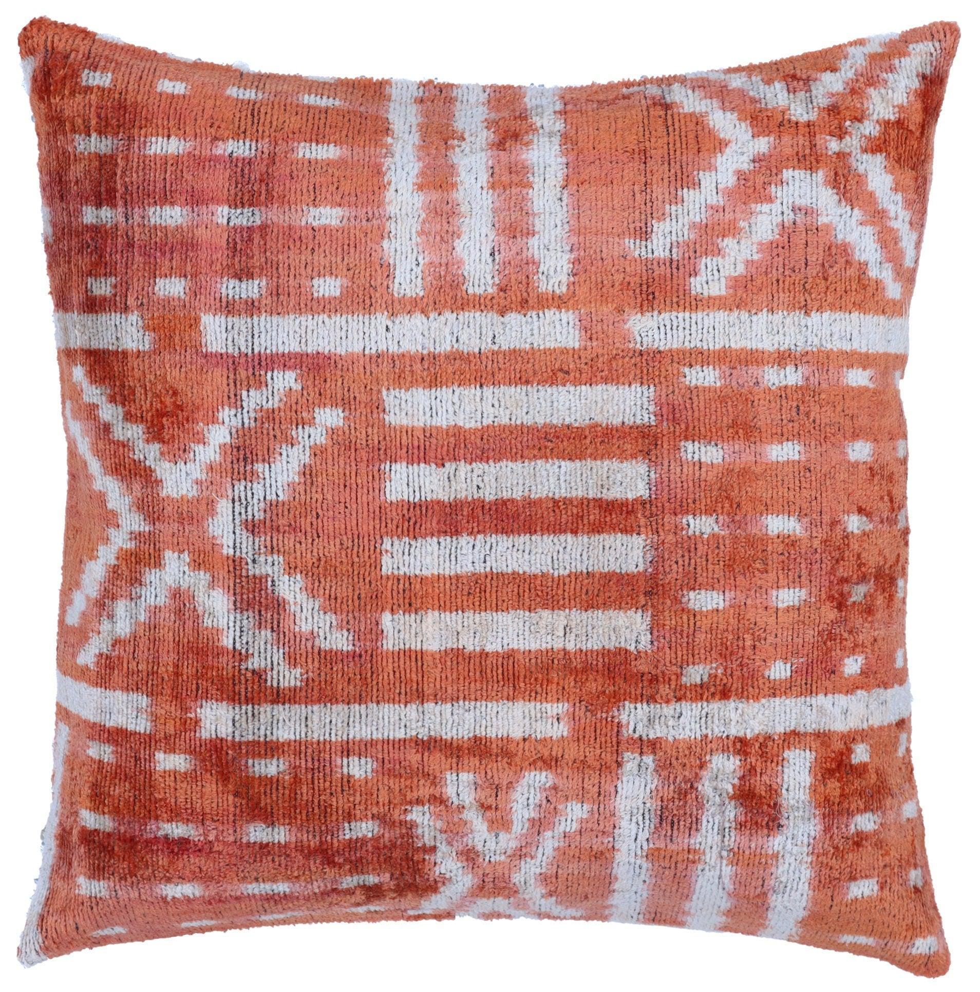 Decorative pillow with orange and white pattern on a white background