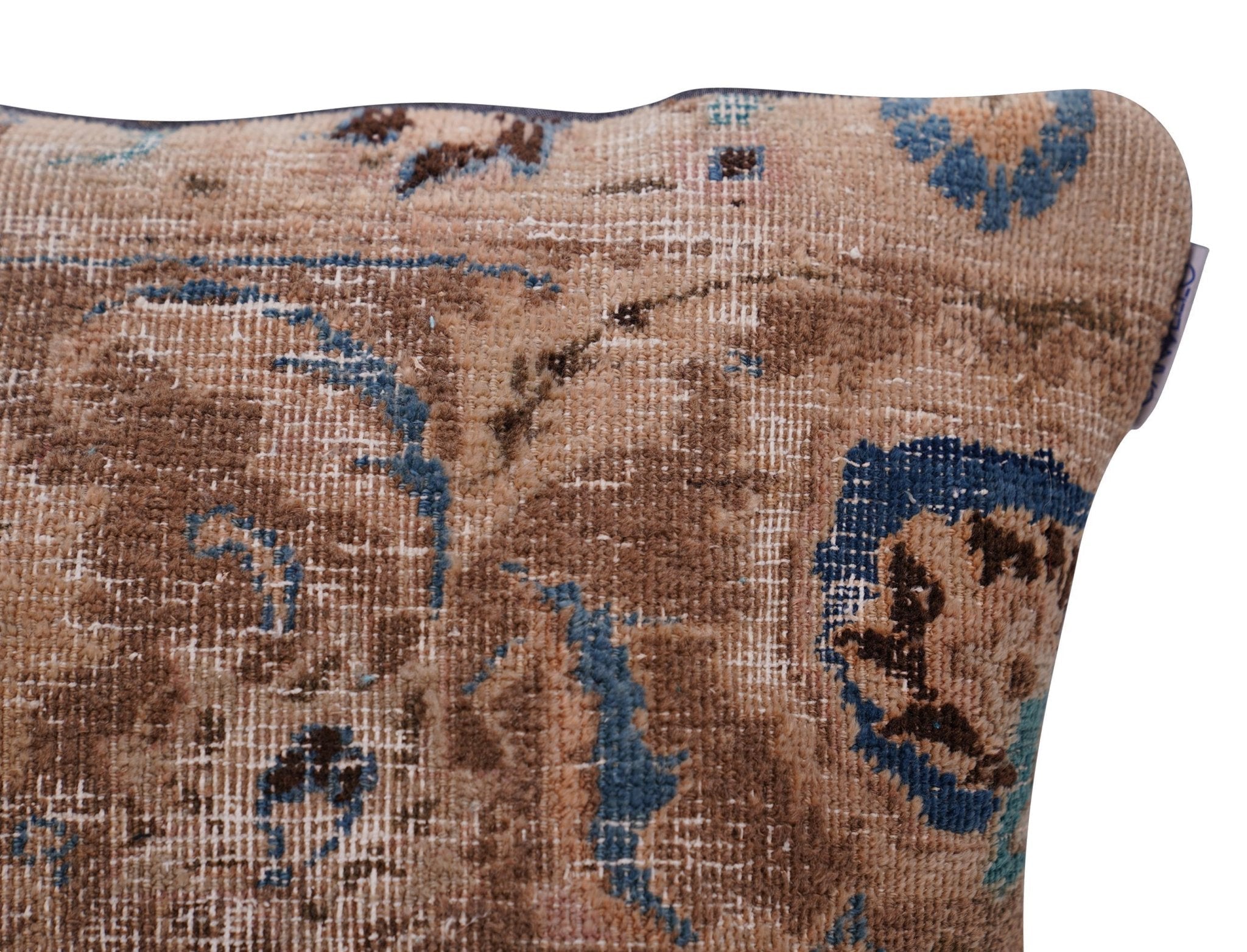 Close-up of a patterned pillow with brown and blue colors on a white background