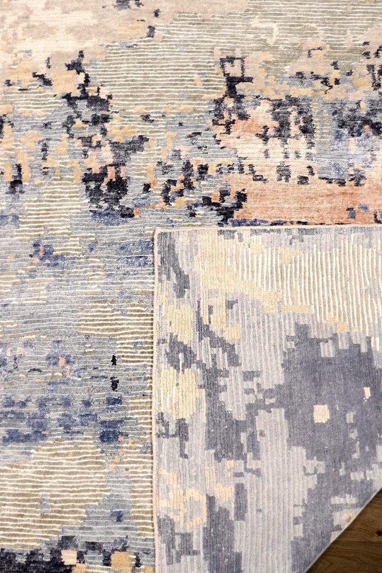 Two abstract patterned rugs on a wooden floor.