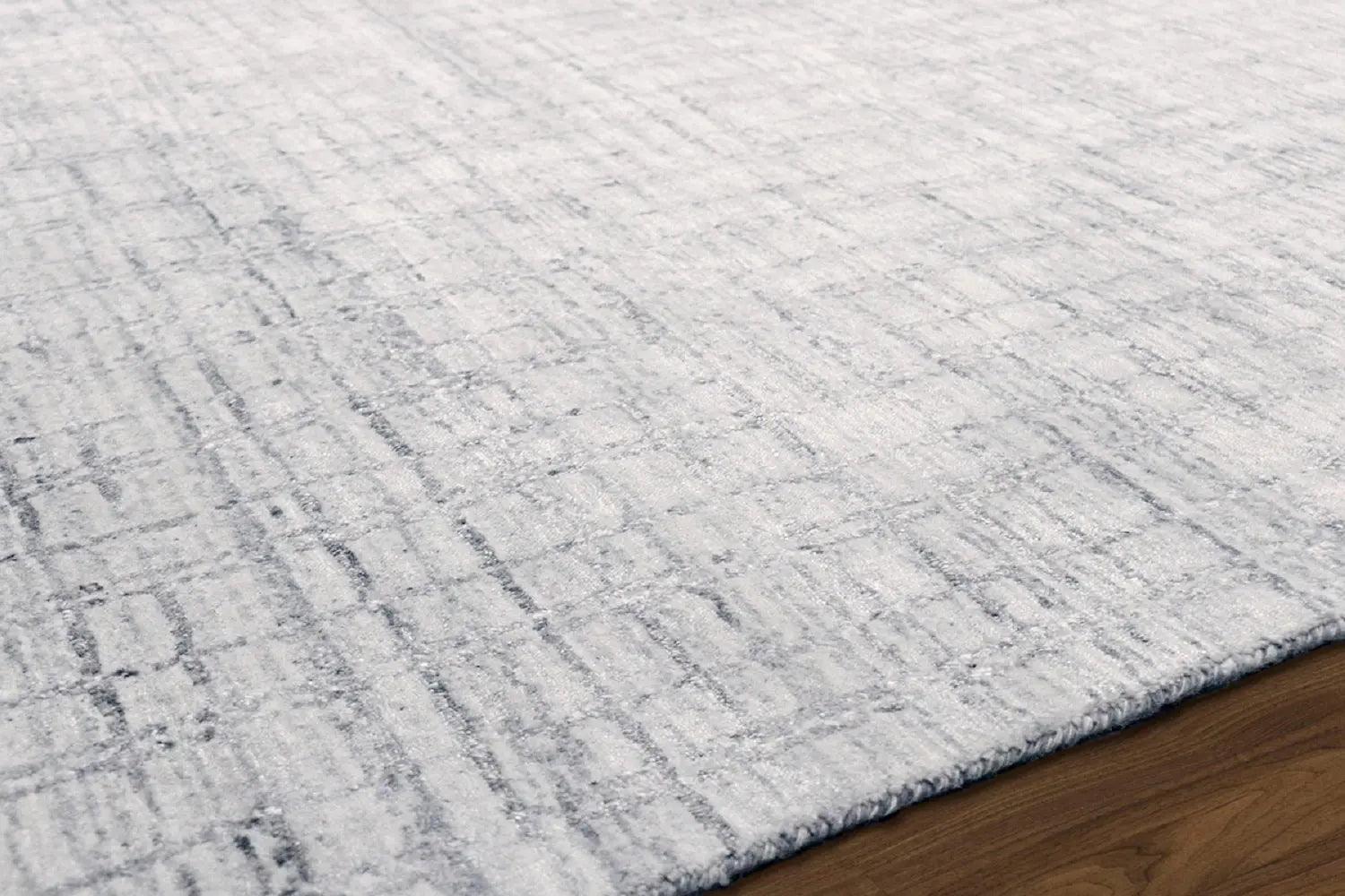 Close-up of a textured gray rug on a wooden floor