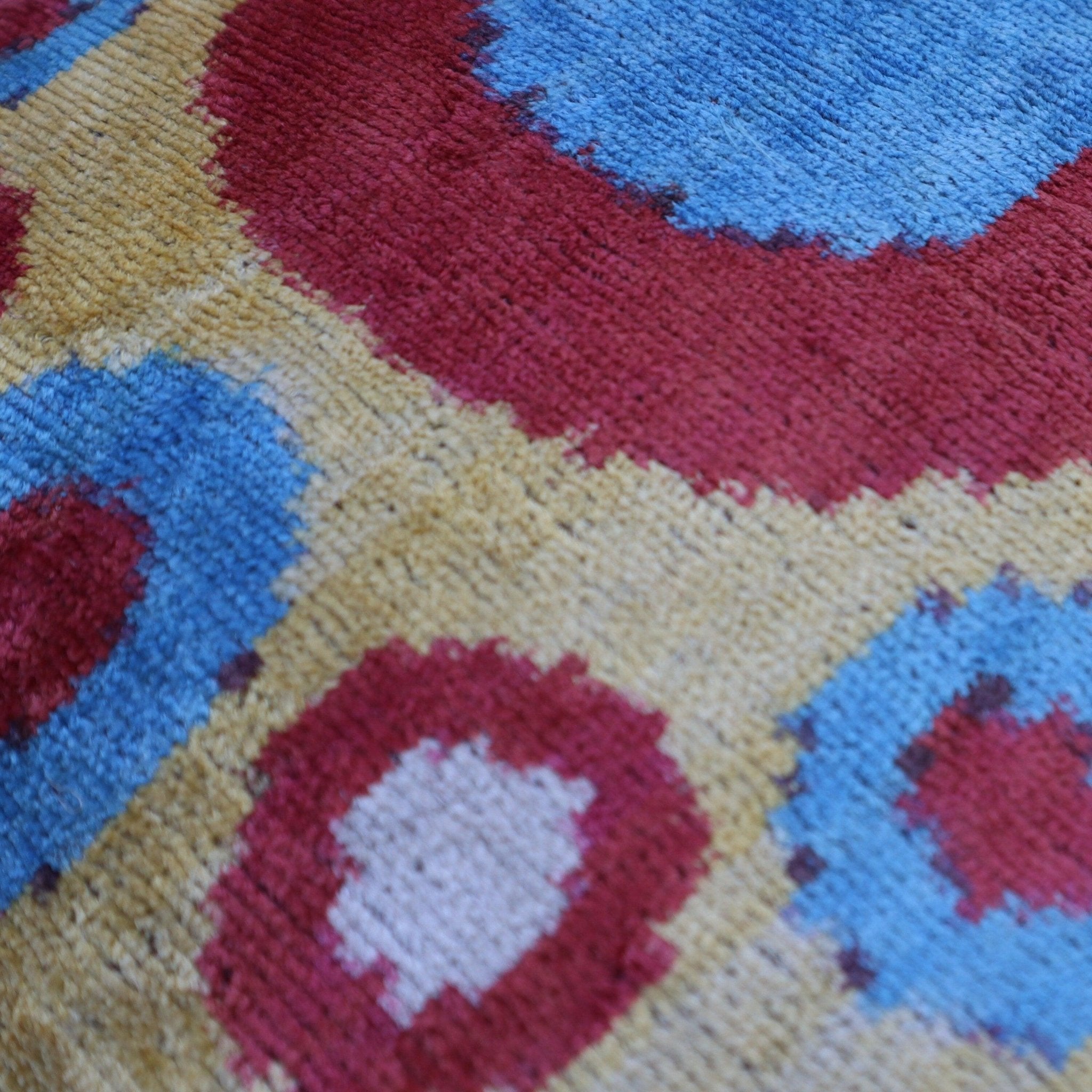 Close-up of a colorful patterned fabric with red, blue, and yellow colors.