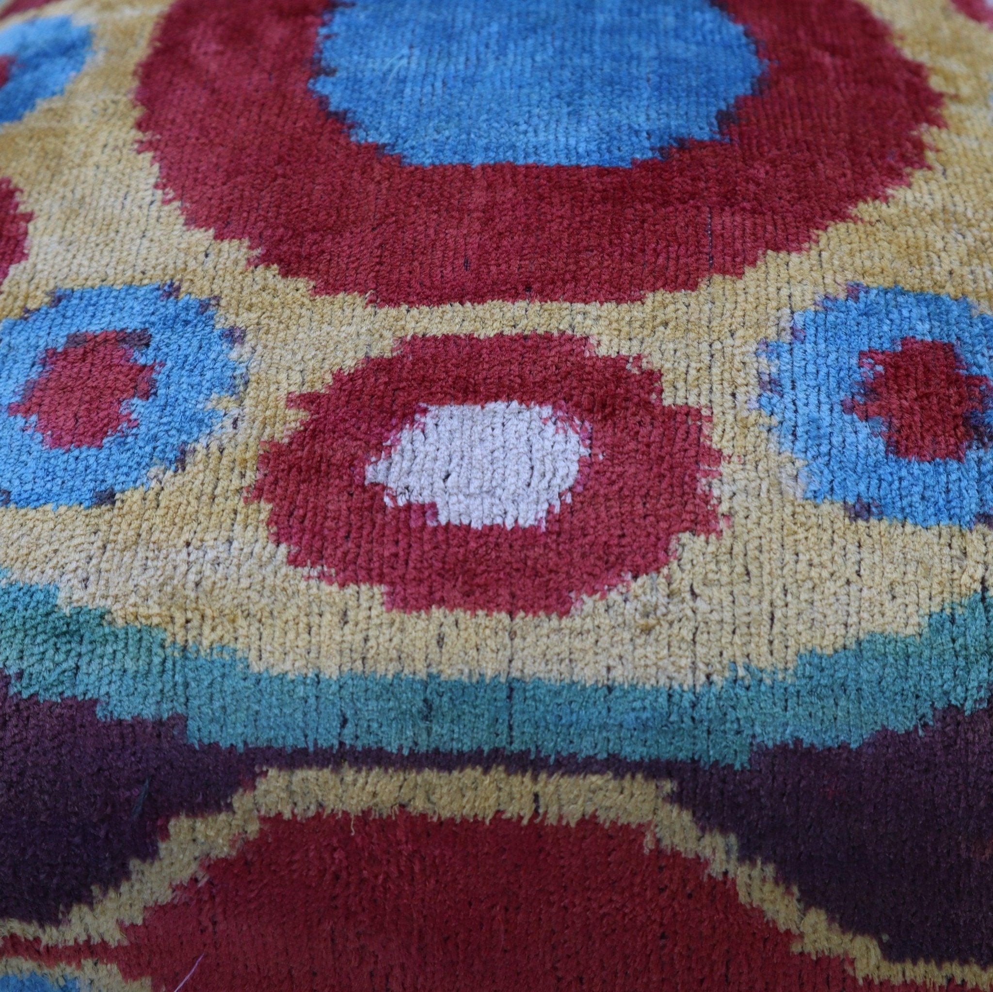 Close-up of a colorful patterned fabric with red, blue, and yellow colors.