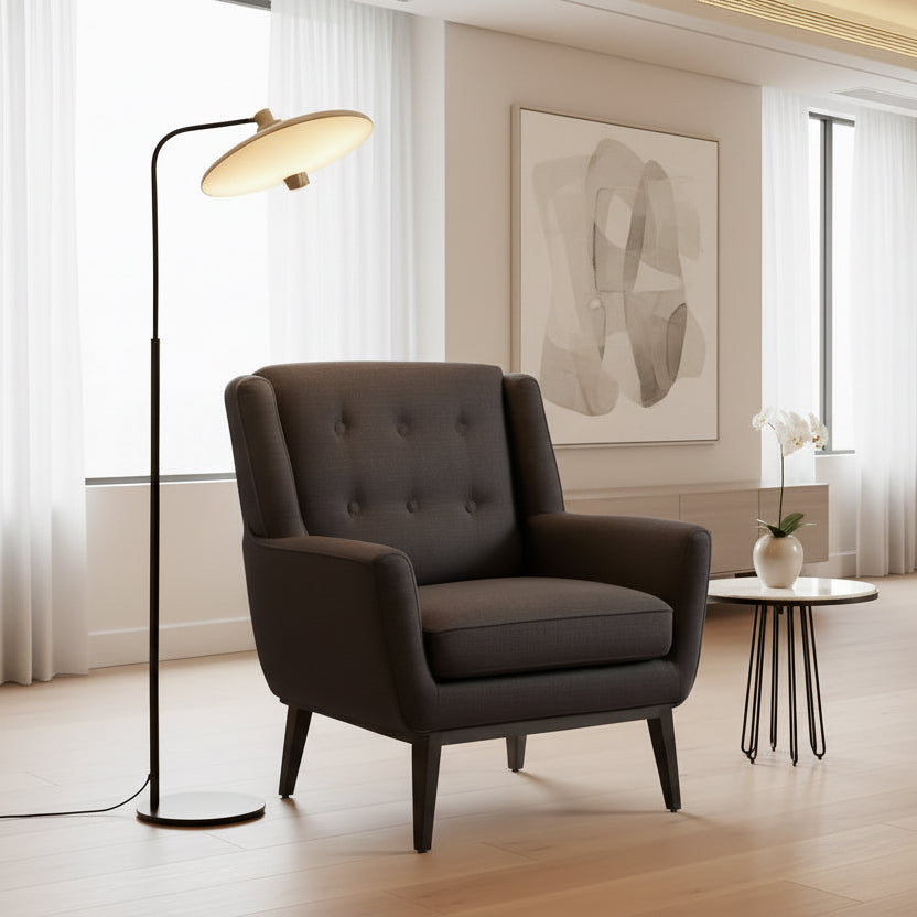 Gray armchair in a room with a floor lamp and side table.