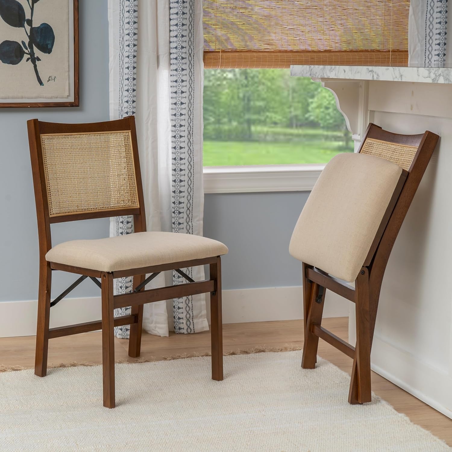 Two wooden chairs with beige cushions in a room with a window and decorative elements.