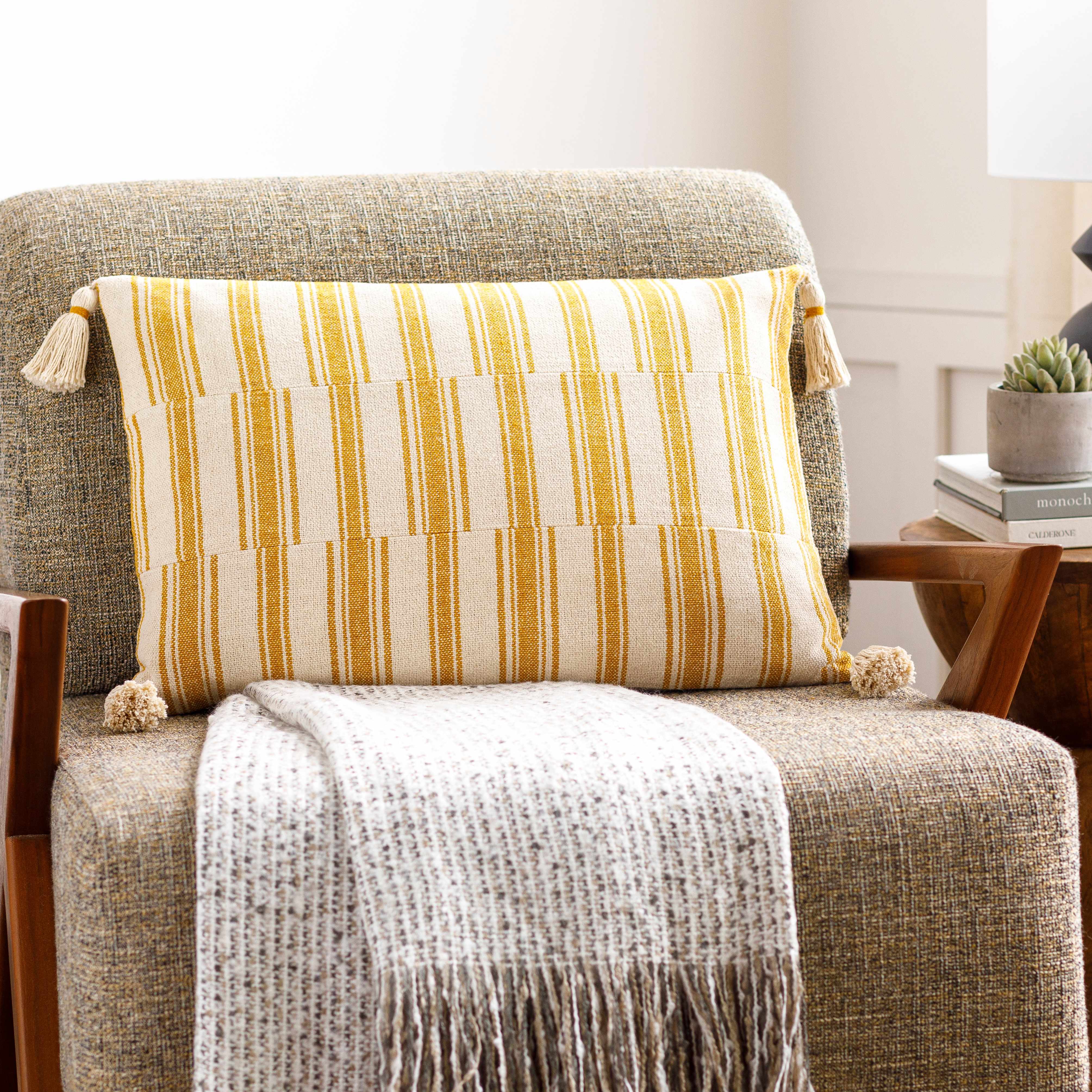 Chair with a striped pillow and blanket in a home setting