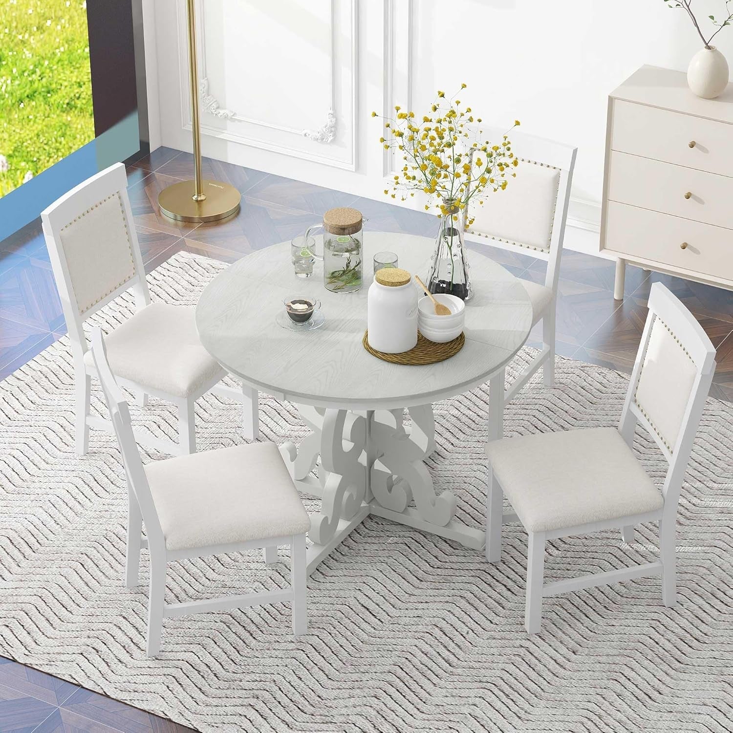 Round dining table with four chairs in a modern living room.