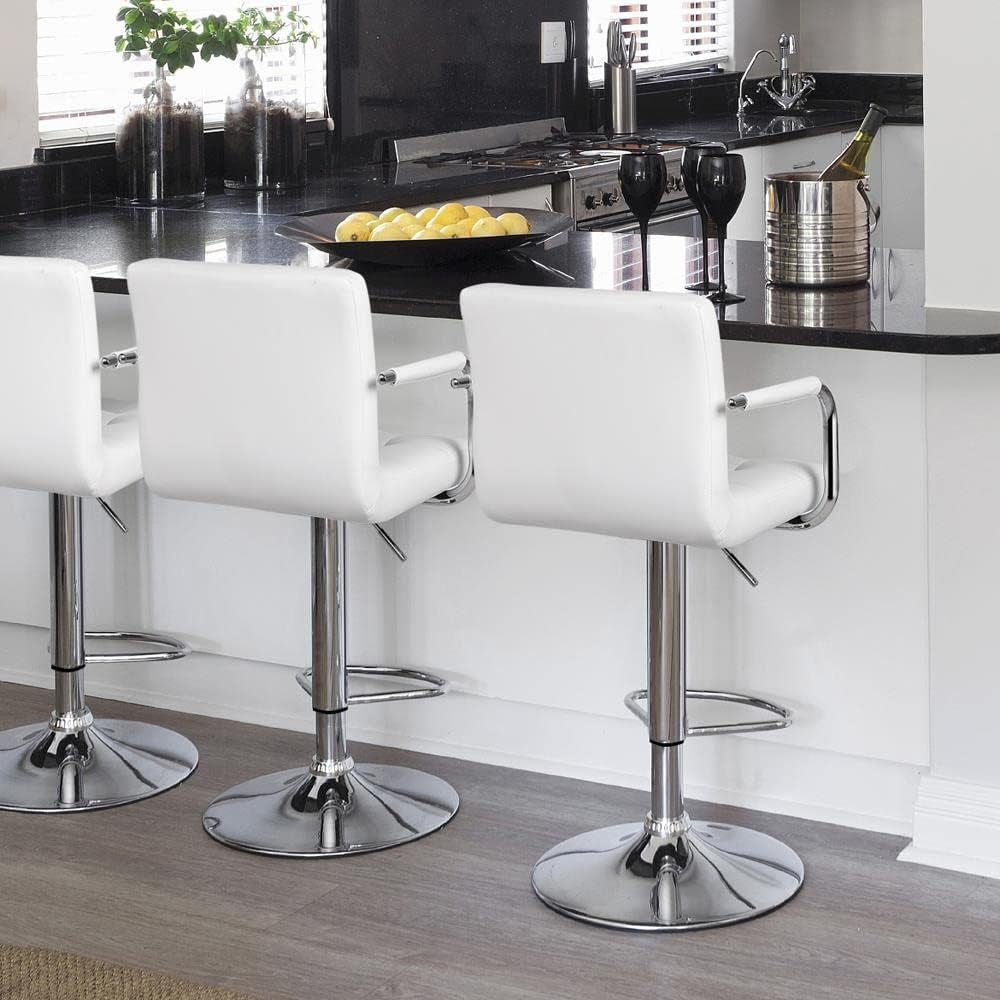 Modern kitchen with white bar stools and a black countertop.