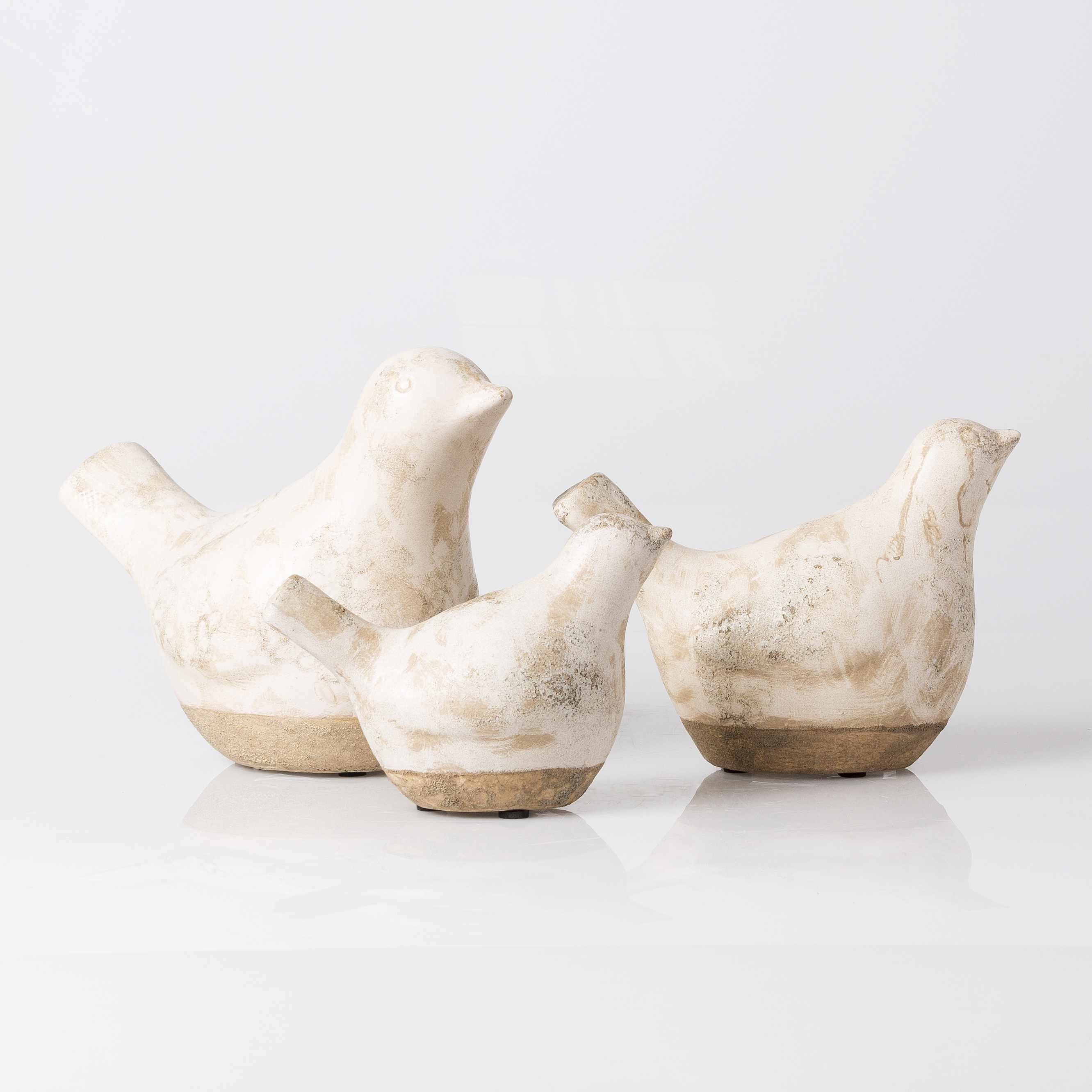 Set of four ceramic bird figurines on a white background
