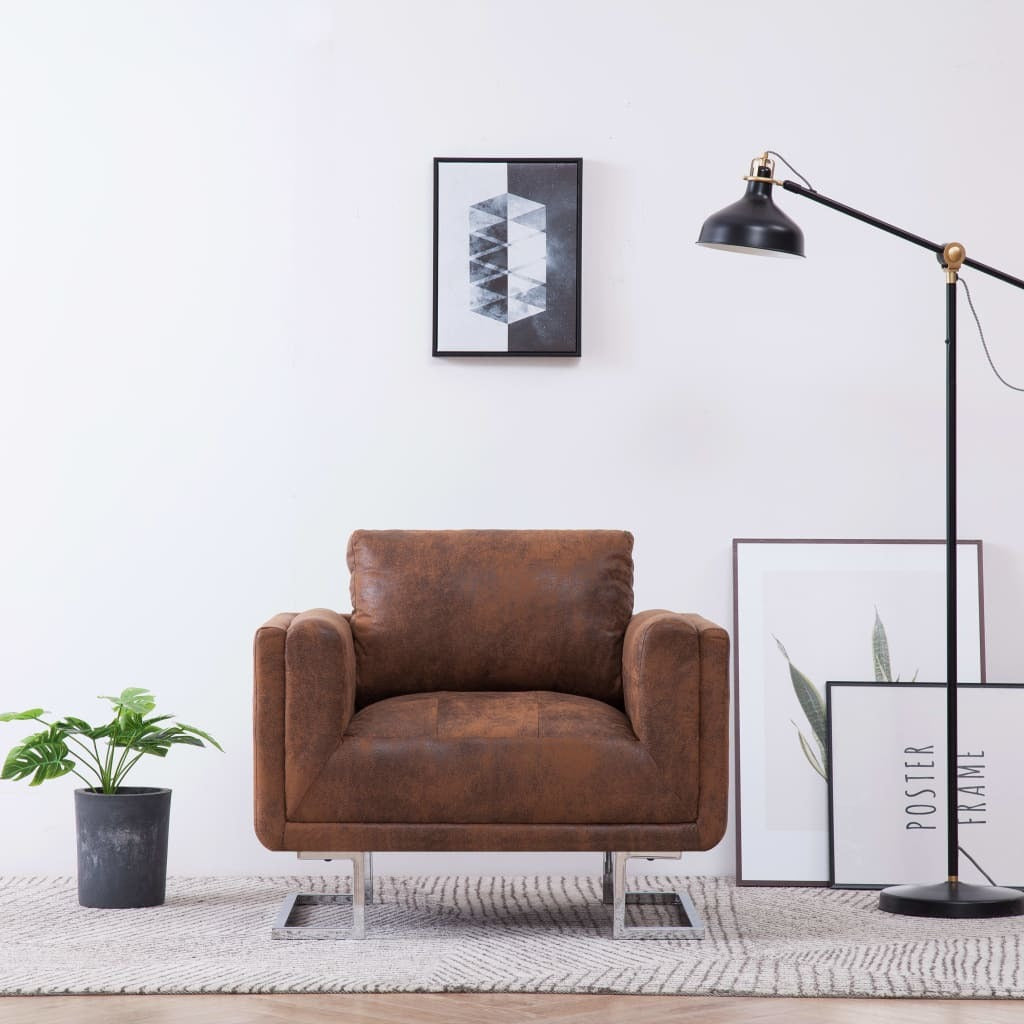 Brown leather armchair in a modern living room with a lamp, plant, and framed art on the wall.