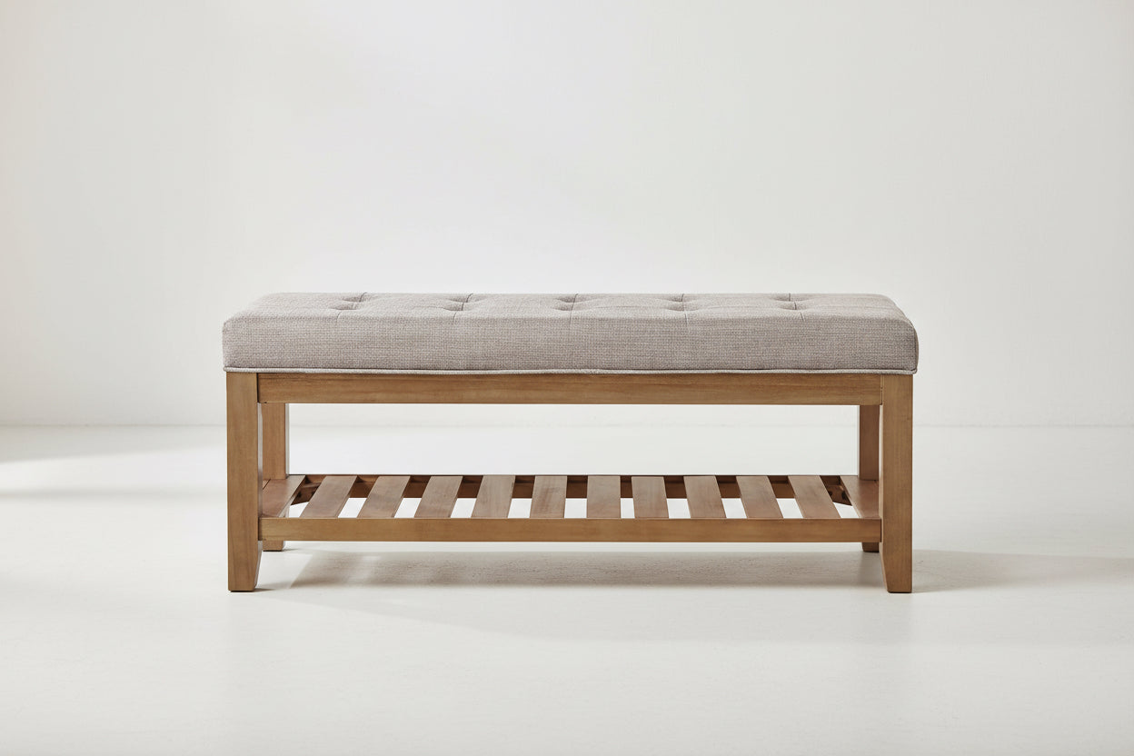 Wooden bench with a tufted cushion seat on a white background