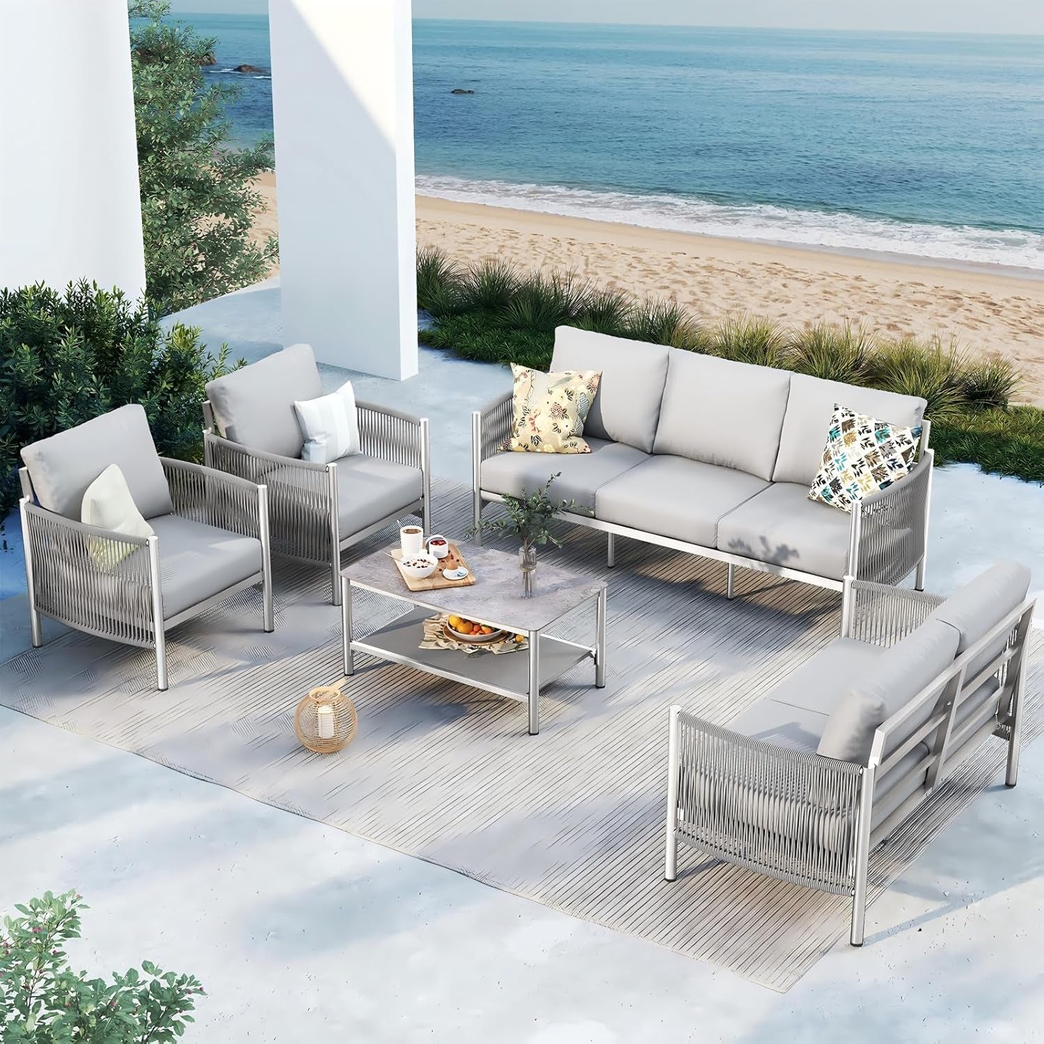 Outdoor patio set with gray sofa and chairs on a patio with ocean view